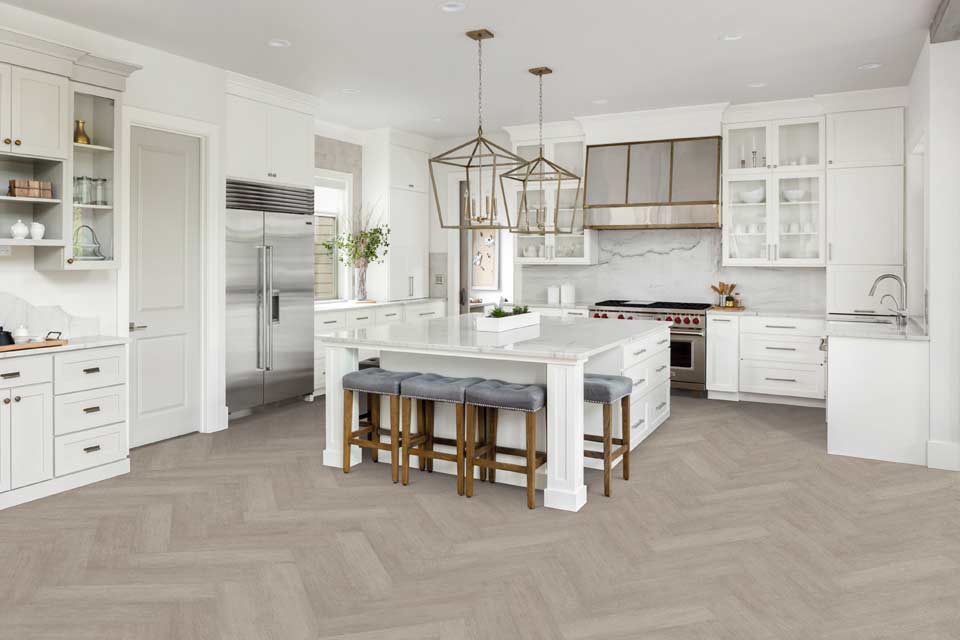 gray toned luxury vinyl in herringbone in all white modern kitchen